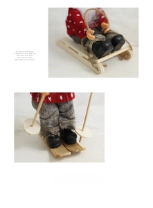 Detail of Christmas Santa dolls on wooden sledges featuring red knits and fur trim boots
