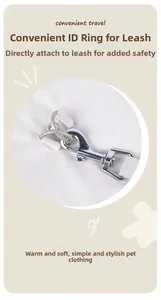 Detail of metal D-ring on white dog coat for convenient leash attachment and outdoor travel