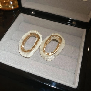 Gros plan de boucles d'oreilles ovales avec texture marbre blanc dans un écrin cadeau