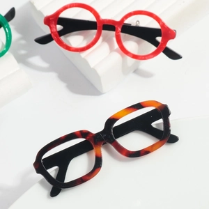 Detailed view of colorful acetate mini glasses brooches in red and tortoiseshell patterns