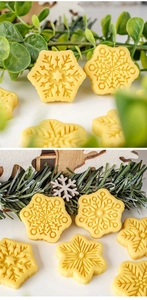Close-up of yellow snowflake-shaped cookies with detailed patterns and festive winter decor