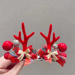 Detailed view of red felt reindeer antler hair clips with glitter ornaments and bows