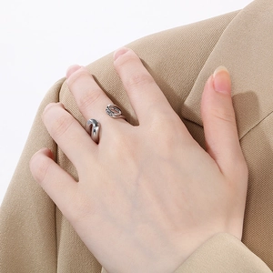 Macro detail of a silver safety pin style twisted open ring on model's index finger