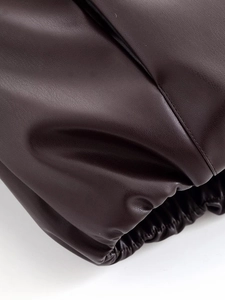 Détail d'une veste en cuir marron foncé avec poignets élastiques et surpiqûres