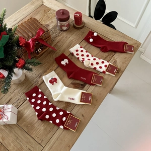 Detail of five festive Christmas cotton socks with apple embroidery on a wooden table