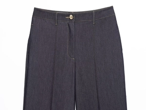 Gros plan du pantalon en denim bleu foncé à taille haute avec bouton fleur en métal doré