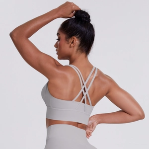 Close-up of light grey sports bra featuring intricate multi-strap crisscross back design