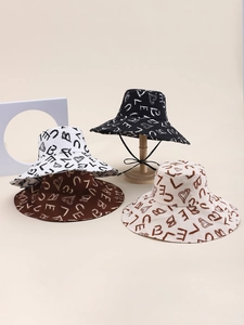 Close-up of wide brim bucket hats in four colors with graffiti letters and heart patterns
