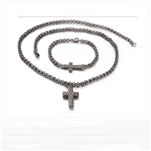 Detail of vintage stainless steel cross necklace and bracelet set with hammered texture