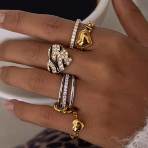 Set of gold and silver heart-shaped rhinestone stackable rings on hand for fashion