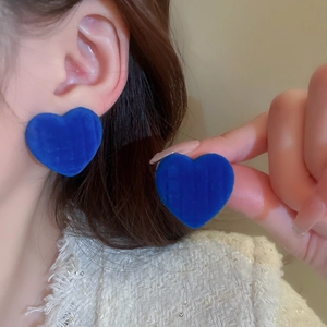 Detail view of blue flocked heart earrings with velvet texture for elegant style