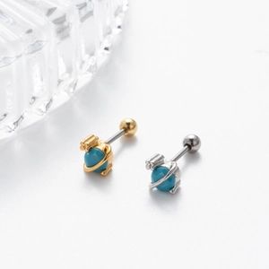 Detailed macro shot of planet-style screw-back cartilage earrings in gold and silver finish