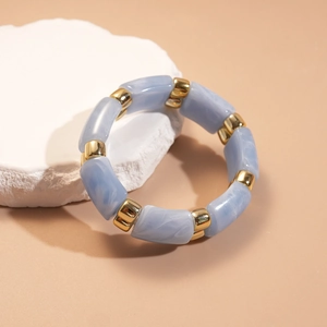 Macro detail of acrylic marble bead bracelet with polished gold metal spacers