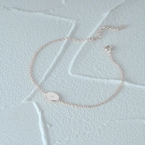 Macro detail of silver S925 oval pendant with engraved star on a delicate O-chain