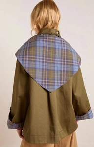 Detail of olive green coat featuring a triangle plaid shawl design and checkered cuffs