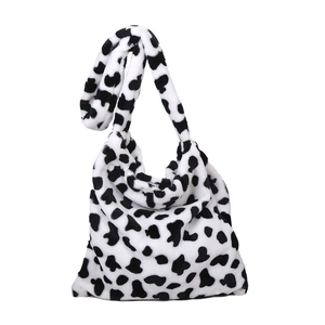 Chic black and white cow print plush shoulder bag with a soft faux fur texture
