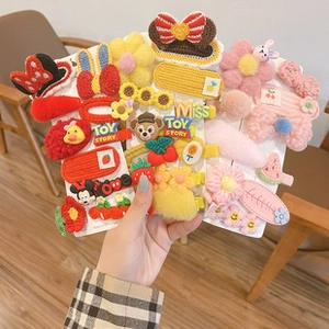 Détail de pinces à cheveux tricotées main aux motifs variés de fruits et fleurs colorés
