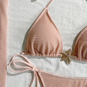 Detail of pink waffle texture bikini top featuring a gold rhinestone starfish ornament