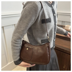 Close-up of vintage brown shoulder bag showing front pocket and metal clasp detail