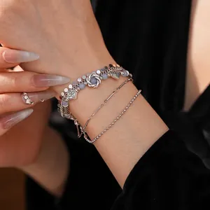Vintage layered silver bracelet with floral charms, metallic discs and purple beads