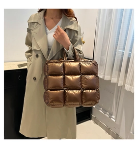 Dettaglio della grande borsa tote trapuntata color bronzo con manici imbottiti e soffici