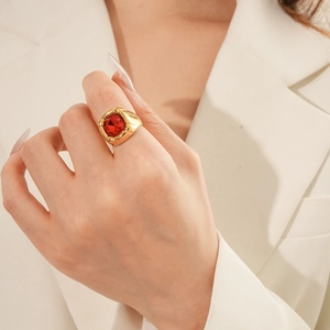 Primo piano di un anello d'oro vintage con zircone rubino indossato da un modello