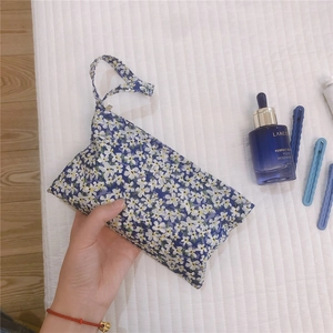 Dettaglio di una piccola borsa organizer floreale blu con cerniera per cosmetici