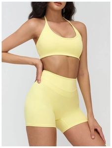 Détail du soutien-gorge de yoga jaune à licou et du short de sport sur un mannequin