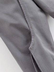 Macro detail of the gray cropped shirt showing double-needle stitching and fabric texture