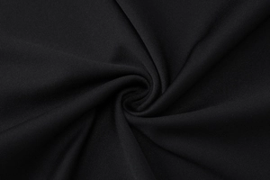 Gros plan sur un tissu noir texturé avec des plis élégants et des ombres douces