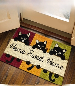 Detail showing three black cats on a colorful Home Sweet Home coir style doormat