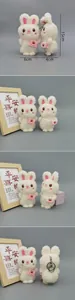 Detailed views of a white plush rabbit keychain with pink ears and cherry bag accessory