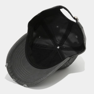 Detail view of washed grey baseball cap with distressed brim and adjustable metal buckle