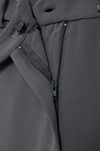 Close-up of high-waist suit trousers showing zipper closure and button details