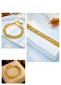 Close-up of golden Byzantine chain bracelet featuring a lobster clasp and round charm detail