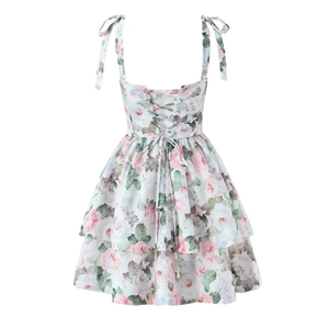 Blumiges Trägerkleid mit Schleifenträgern und Schnürung am Rücken auf weißem Hintergrund