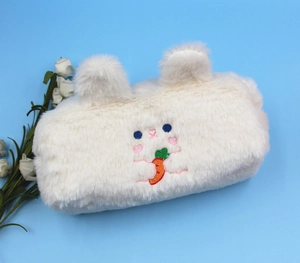 Macro shot of fluffy white plush pencil case with cute rabbit and carrot embroidery
