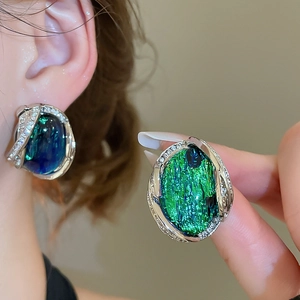 Détail de boucle d'oreille rétro en résine avec pierre aurore et bordure en zircone