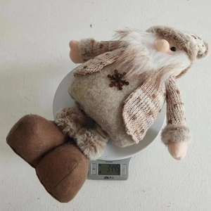 Weight measurement of a forest gnome plush toy on a digital scale showing 344.5g