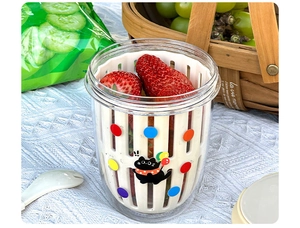 Detail view of a portable salad cup with internal white drain basket and strawberry contents