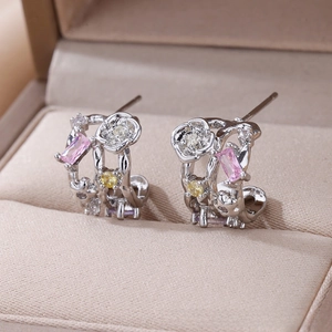 Detail of floral vine earring with pink rectangular zircon and yellow gems in a jewelry box
