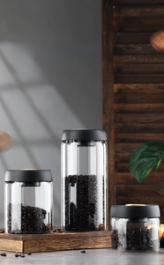 Detailed view of three vacuum-sealed borosilicate glass coffee bean canisters in various sizes