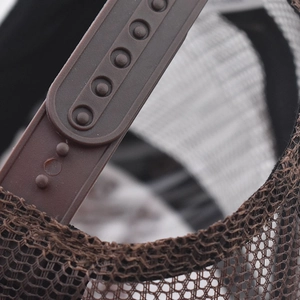 Detail view of the brown adjustable snapback strap and breathable mesh on baseball cap