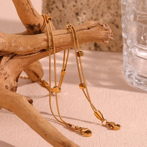 Detail of 18K gold-plated stainless steel double snake chain anklet with cube beads