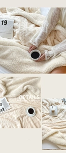 Close-up of thick cream double-layered blanket featuring a detailed cable knit texture