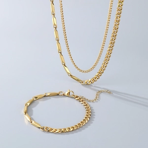 Detail view of gold Cuban link and geometric bar necklace and bracelet jewelry set