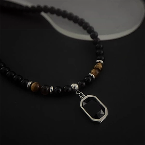 Macro di una collana in pietra naturale con pendente rettangolare nero e bordo in argento