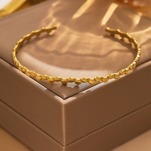Detailed view of the 18k gold plated stainless steel cuff with unique bubble texture