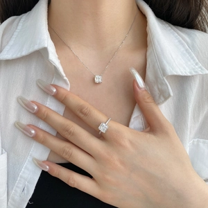 Detailed view of square-cut zircon jewelry set with necklace and ring on a model
