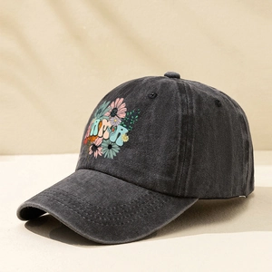 Detail view of the floral embroidery and MAMA print on a washed black baseball cap